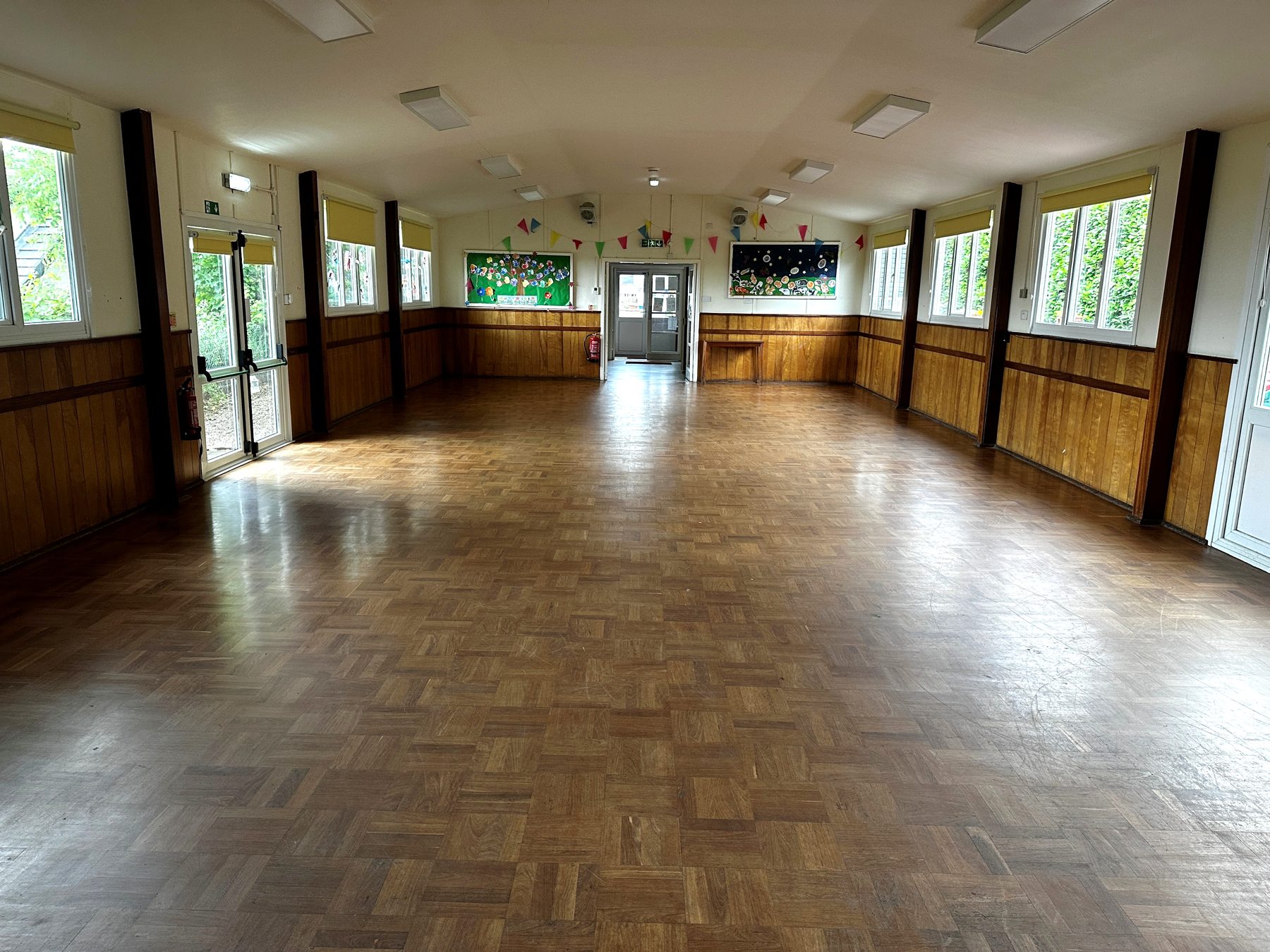 Inside the main hall, showing the parquet floor, wood panelling and windows along both sides